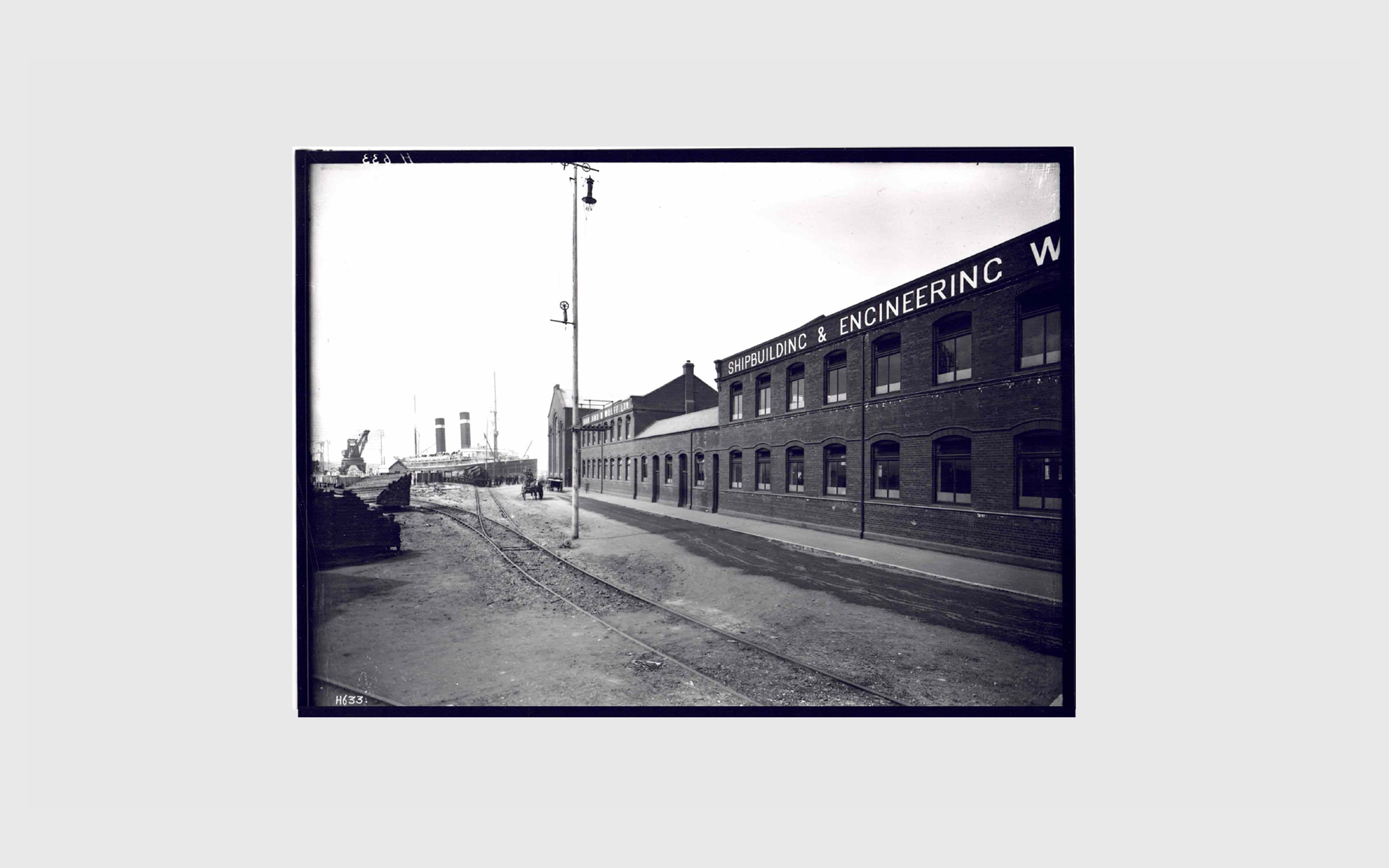 Harland & Wolff archive image showing exterior buildings in the late 1800, early 1900s with ship in background