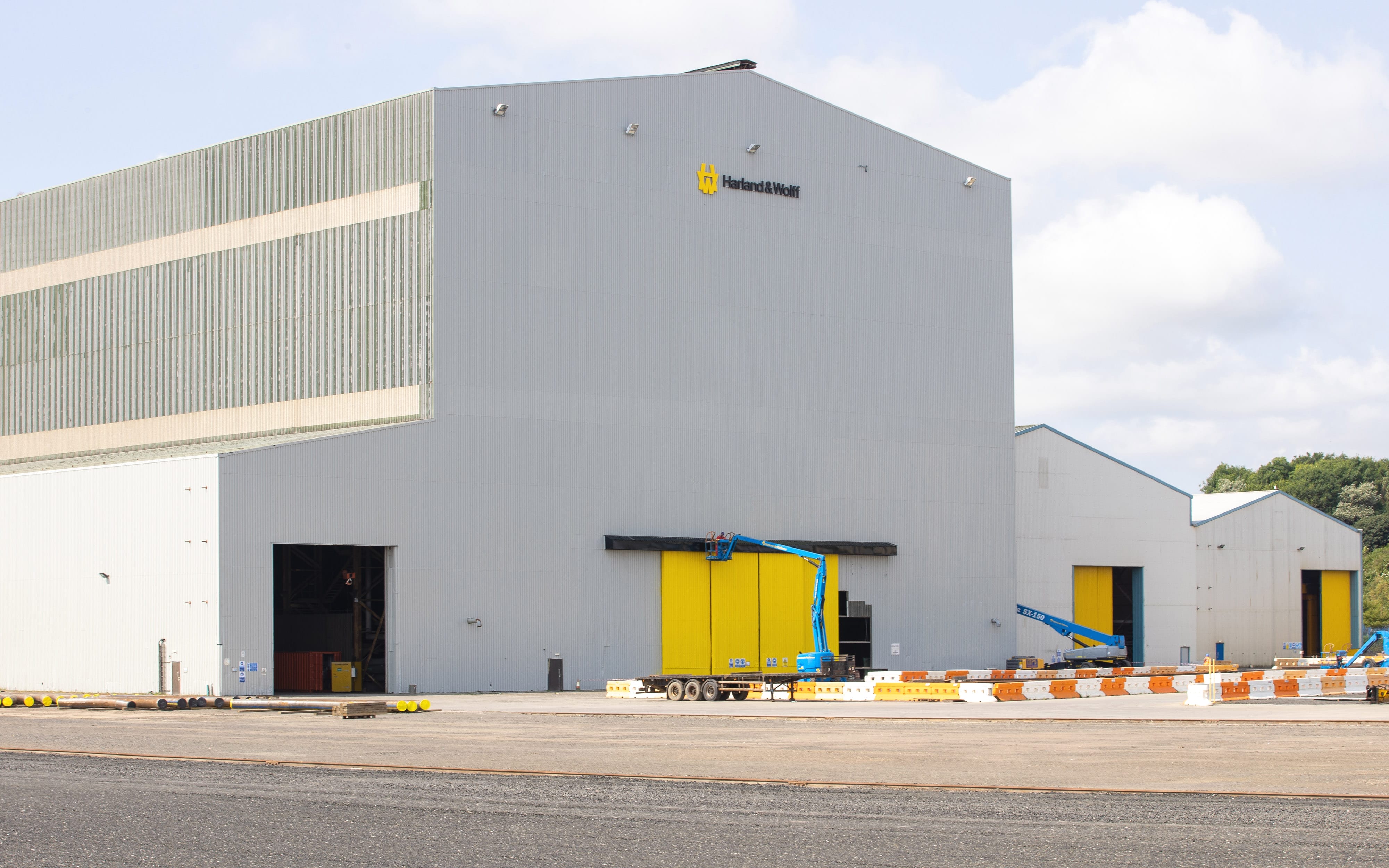 Harland & Wolff shipyard building exterior with yellow logo and doors